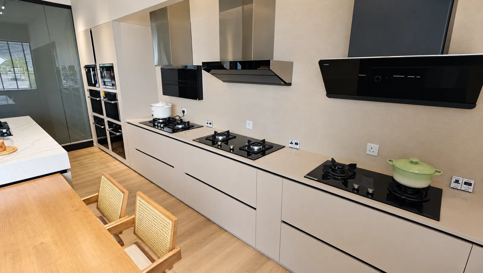 Real Cabchen showroom cooking wall: cream cabinets with several gas hobs and range hoods to compare side by side